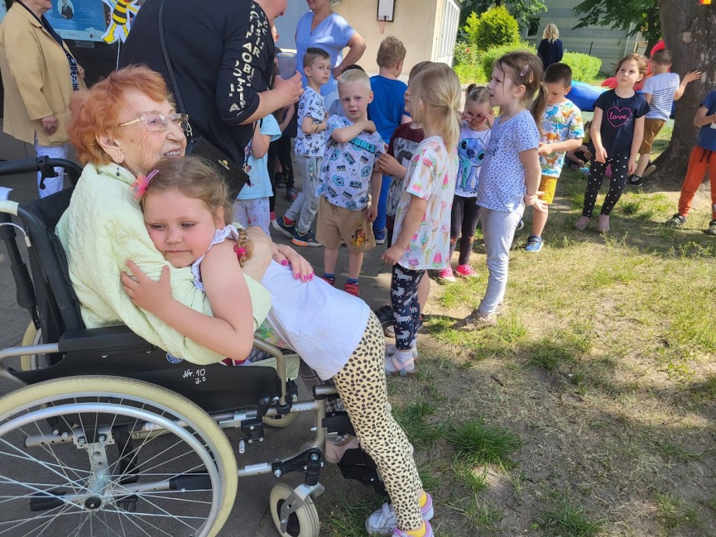 seniorka na wózku przytula dziewczynkę